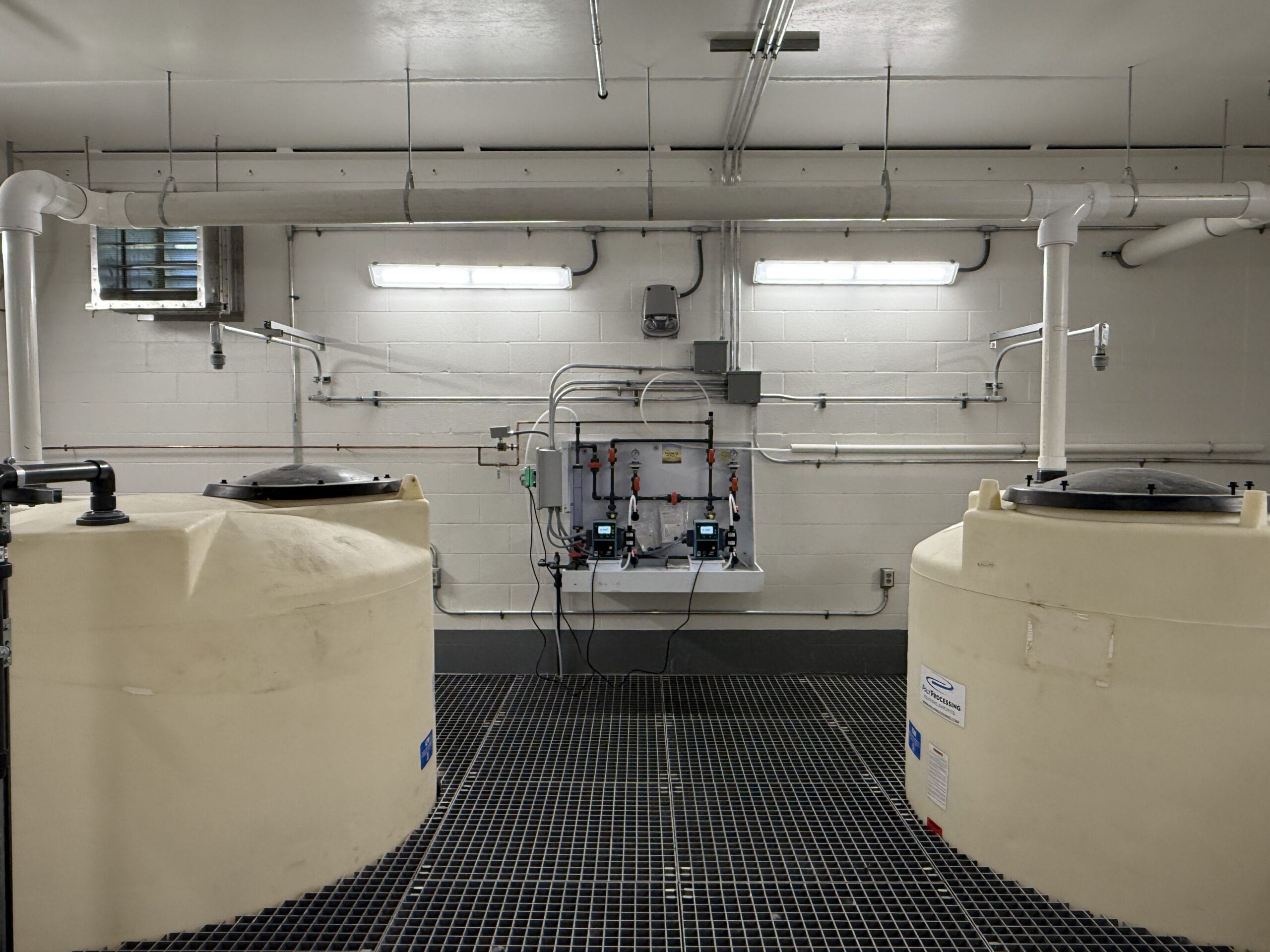 Two large plastic cisterns inside a water treatment facility