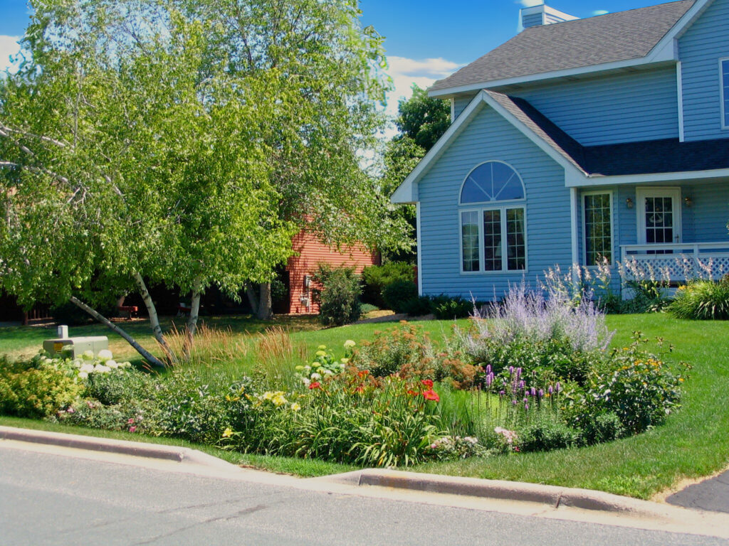 Street view of a residential home with a curbcut raingarden