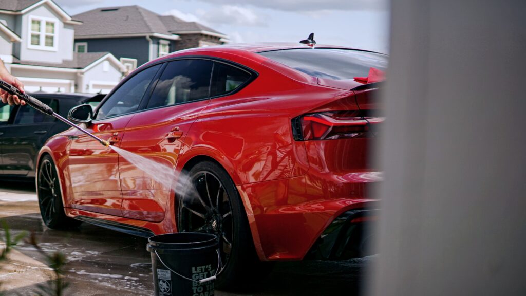 Car in driveway being washed by hand