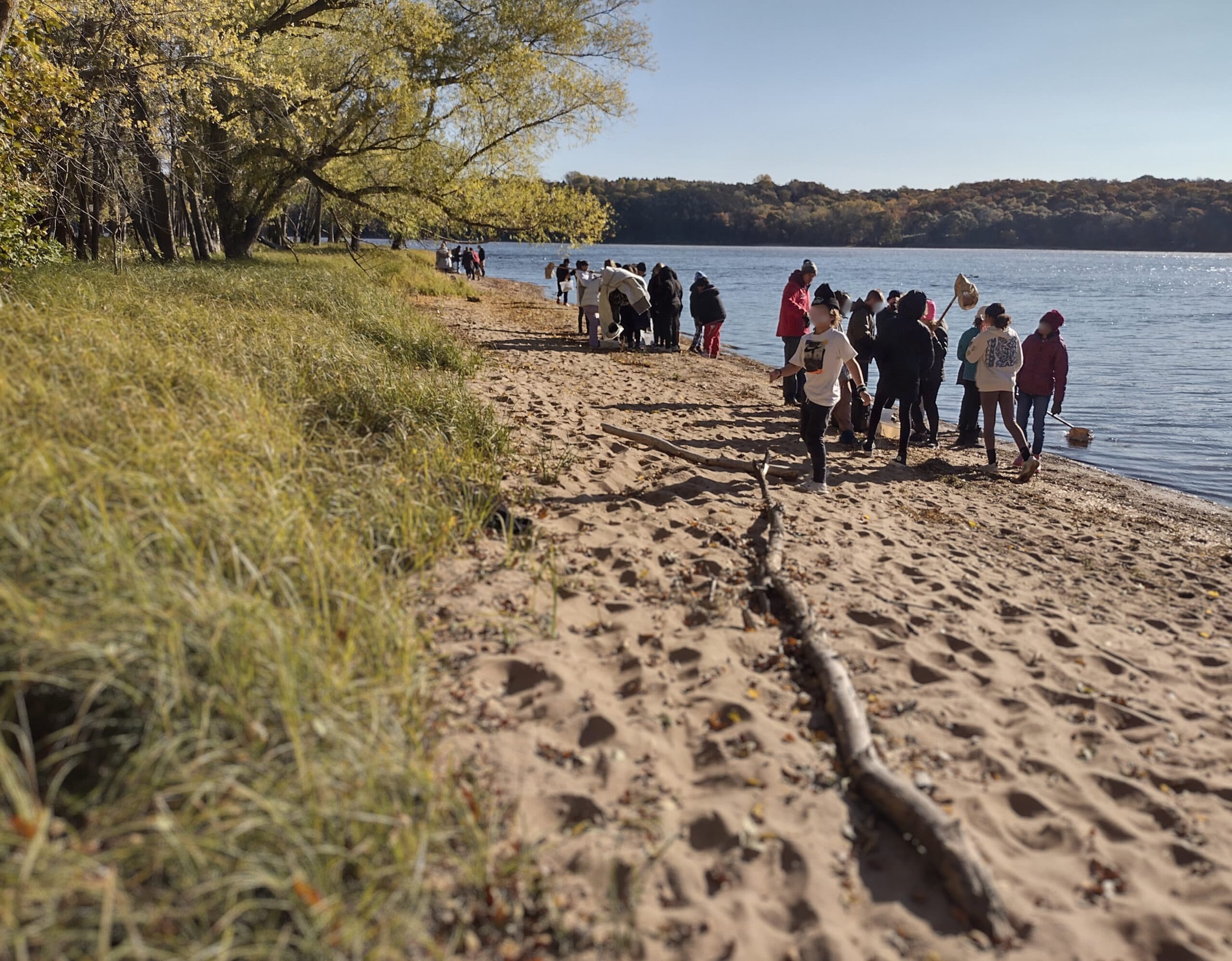 School age students on the shore of a large river
