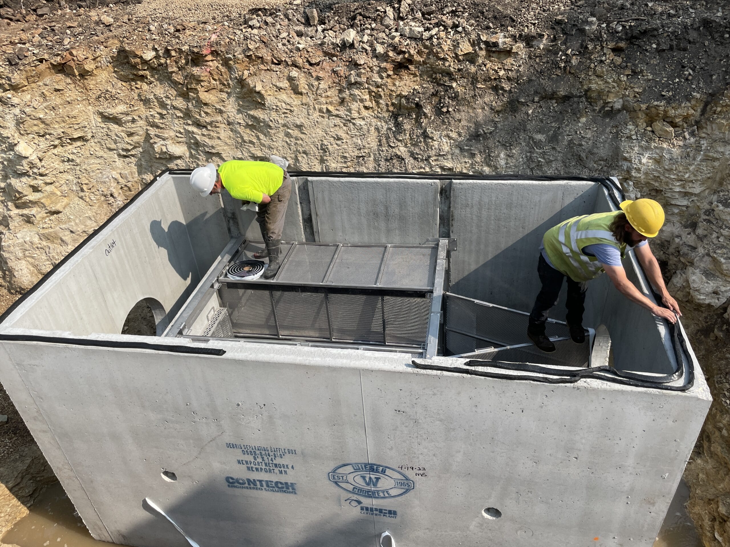 Construction workers inside a large concrete box